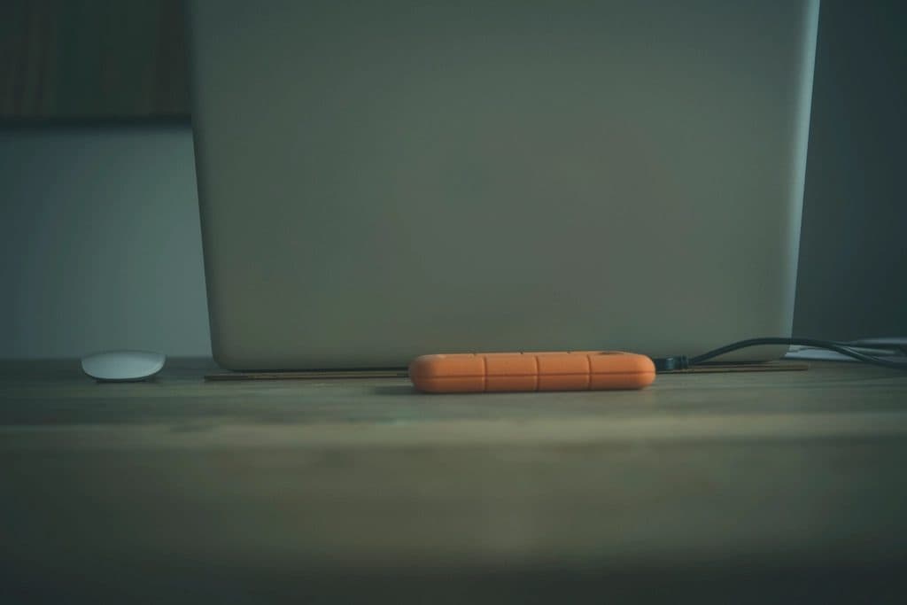 Orange externe Festplatte auf einem Schreibtisch vor einem Computer