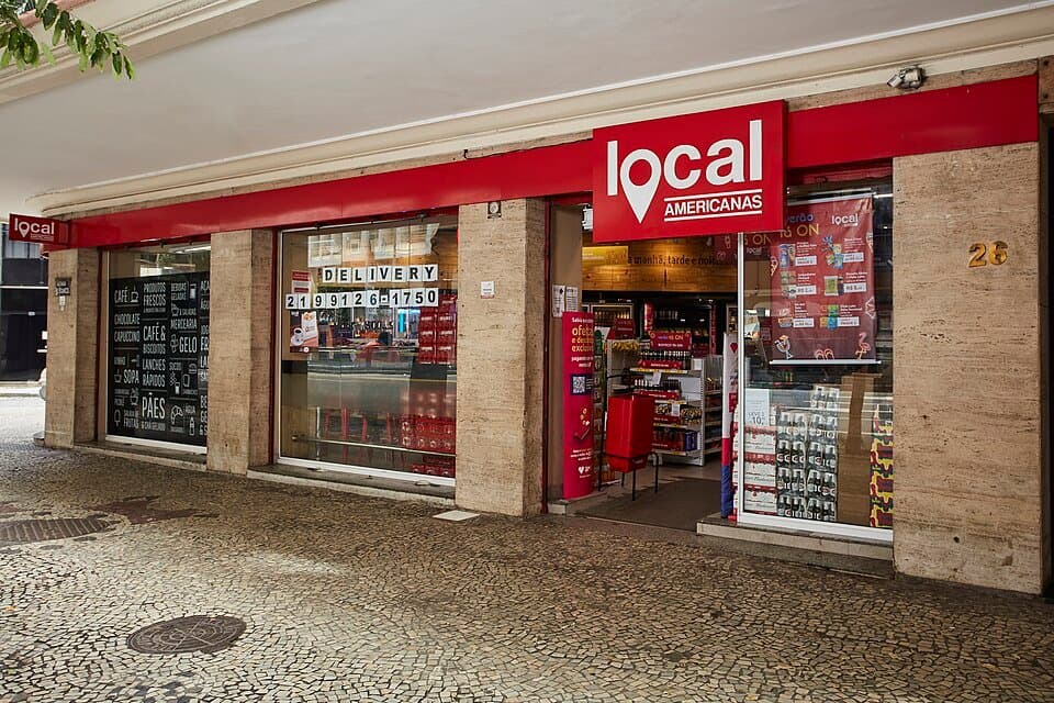 Fachada de uma loja Local Americanas, com letreiro vermelho, numa calçada de pedras portuguesas no Rio de Janeiro, em foto de 2019